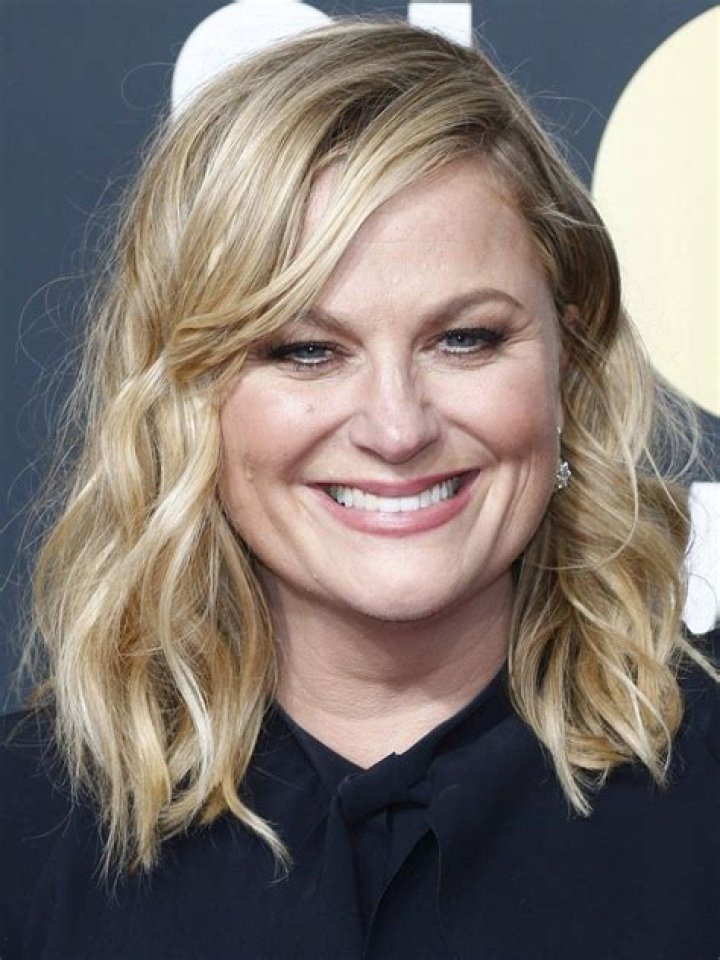Amy Poehler wears a smile as she steps out with a mystery man in Los