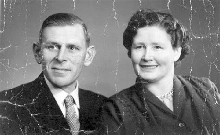an old black and white photo of a woman smiling
