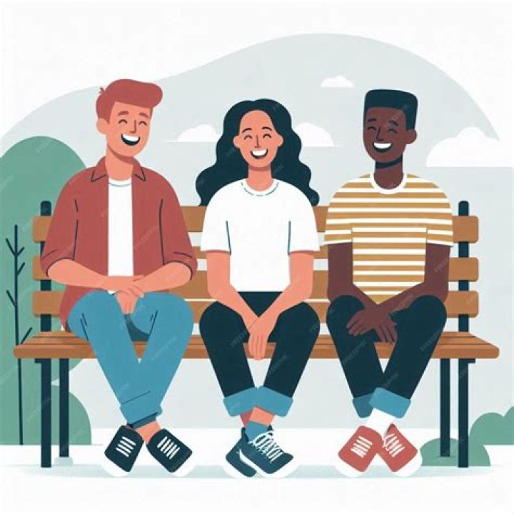 three people sitting on a couch looking at a newspaper