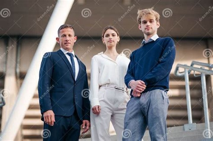 three people standing next to each other in front of a doorway with a
