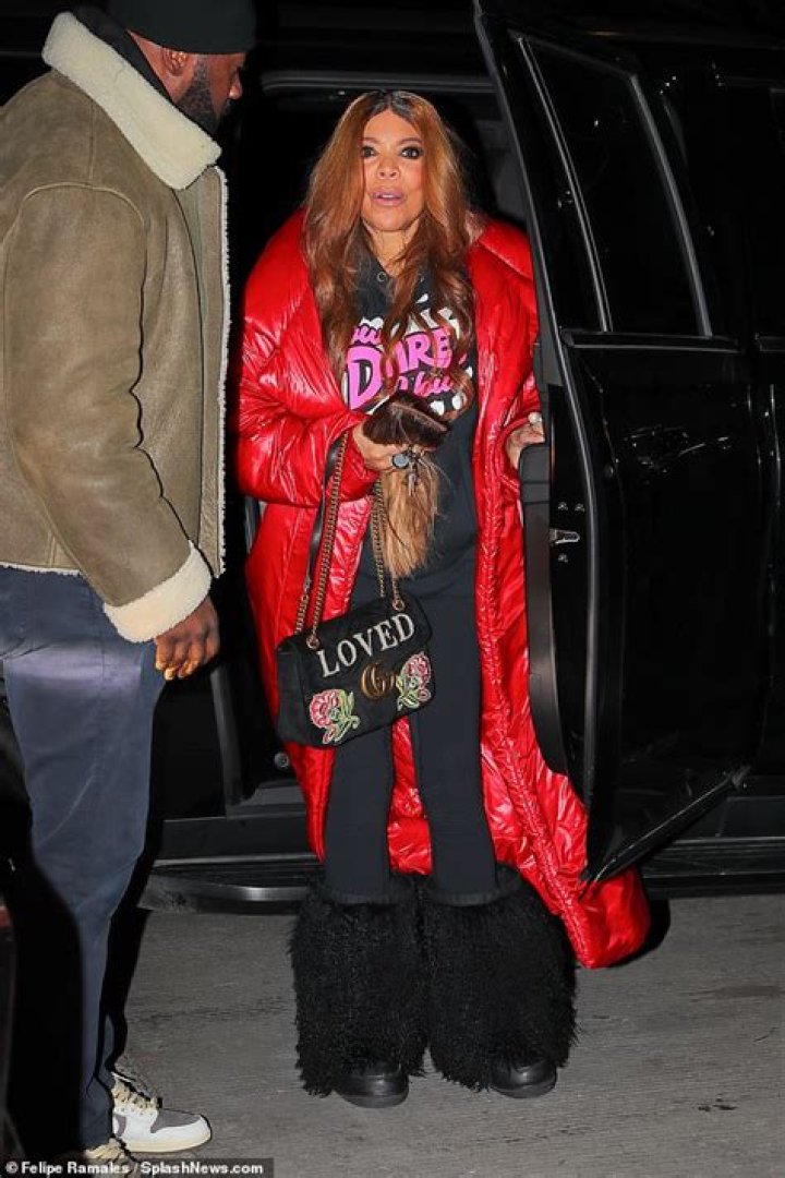 Wendy Williams, 58, takes the arm of a young male companion as she
